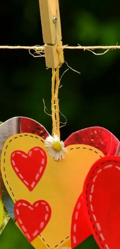 Colorful hearts hanging on a line with a green background.