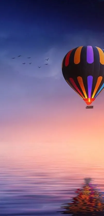 A colorful hot air balloon reflected in a calm sunset sky over water.