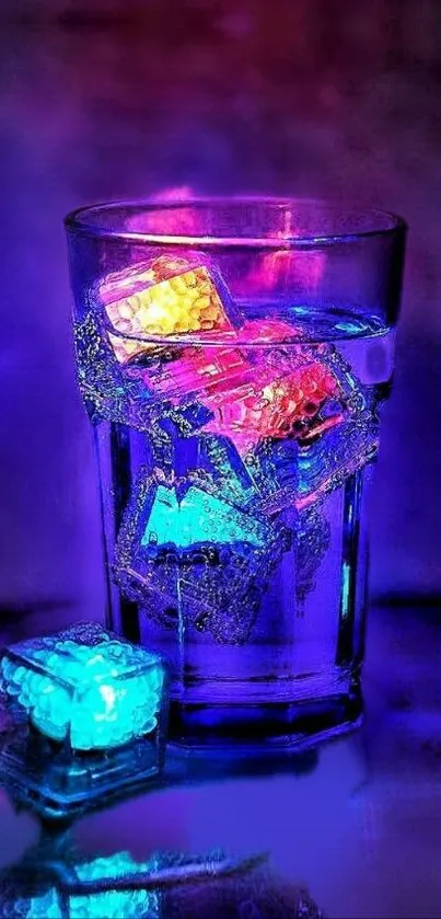 Glass with colorful glowing ice cubes on dark background.