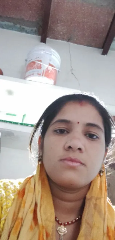 Vibrant portrait of a woman indoors with a yellow and orange scarf.