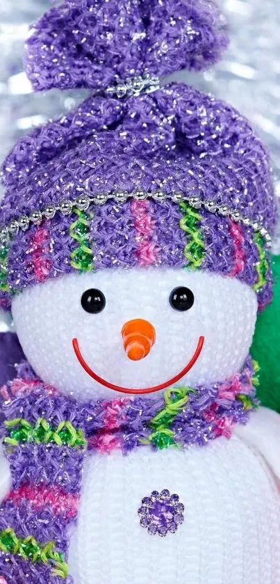 Colorful knitted snowman with a purple hat.