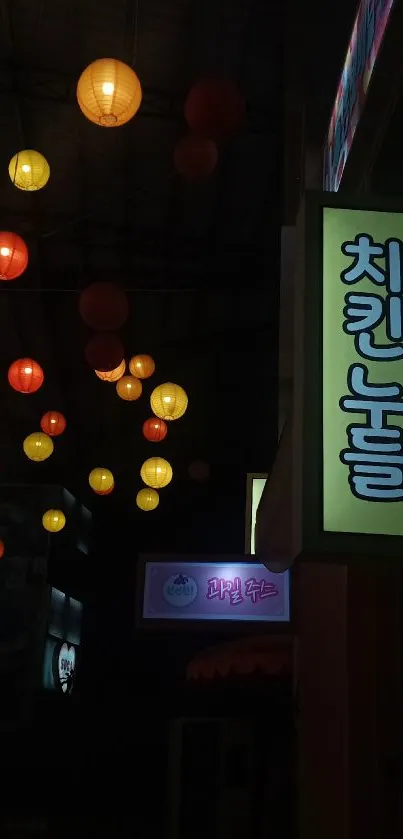 Vibrant lanterns and neon sign lights on a dark city street at night.