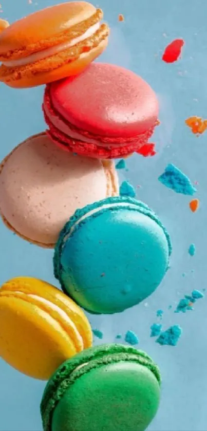 Colorful macarons scattered on light blue background wallpaper.