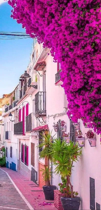 Vibrant Mediterranean street with pink flowers and blue sky.