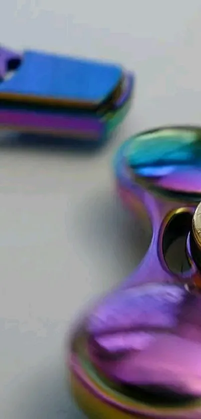 Close-up of a colorful, metallic fidget spinner on a mobile wallpaper.