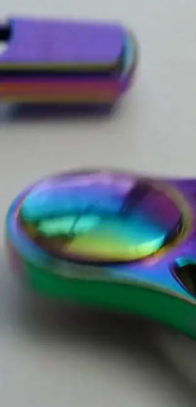 Close-up of a colorful metallic spinner with rainbow hues on mobile wallpaper.