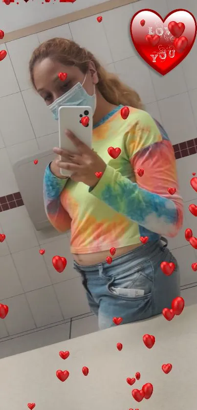 Vibrant mirror selfie with heart icons and tie-dye shirt design.