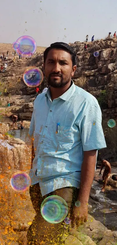 Man standing by waterfall with vibrant bubbles and rocky landscape.