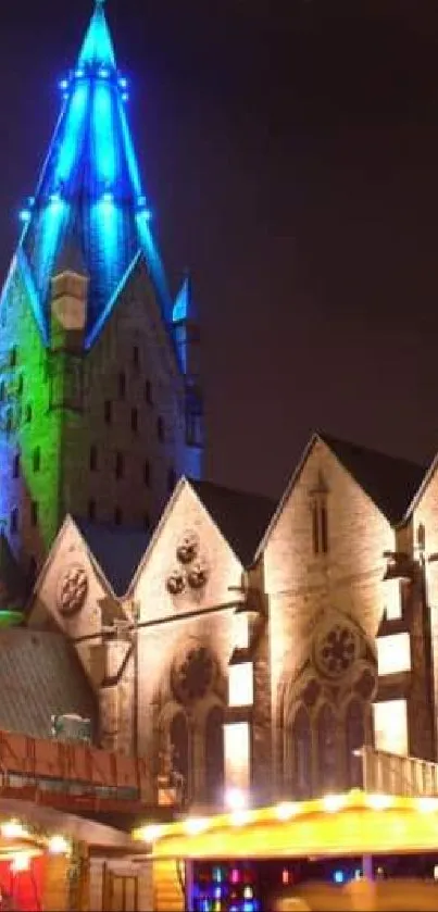 Night view of a lit blue cathedral tower and architecture.