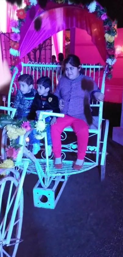 Children in a colorful, flower-adorned carriage enjoying a whimsical night ride.