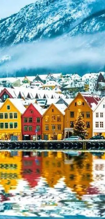 Colorful Nordic village with snowy mountain backdrop and reflection.