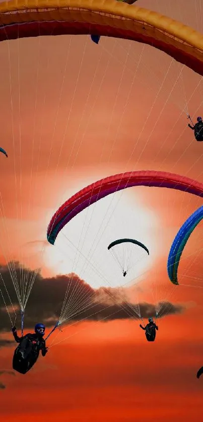 Vibrant paragliders soar against a stunning orange sunset.