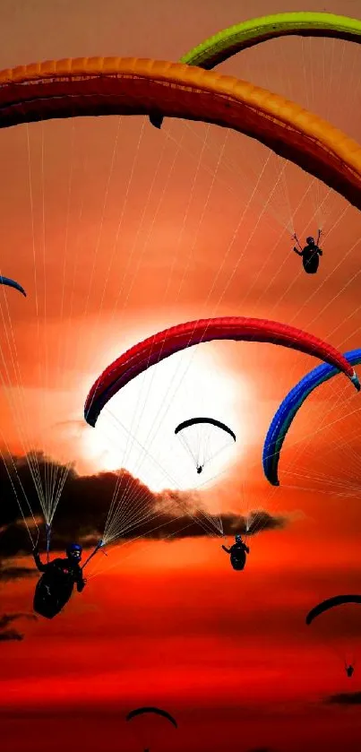 Colorful paragliders soar against a vibrant sunset sky.