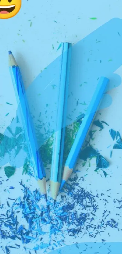 Colorful pencil shavings with blue and green hues and a cheerful emoji.