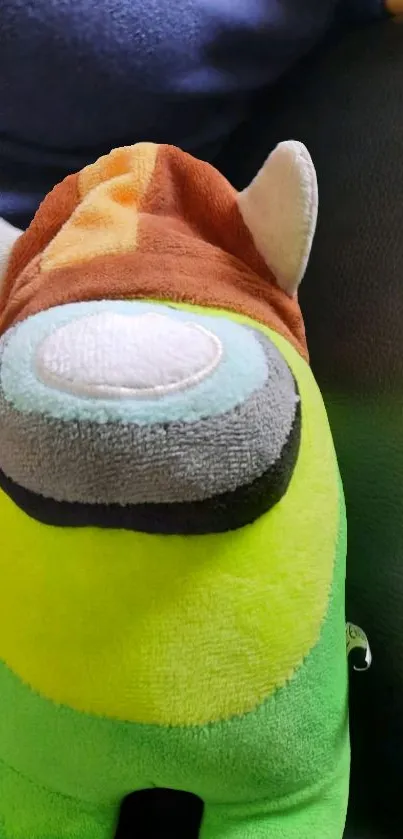 Colorful plush toy with lime green and brown hues on a phone wallpaper.