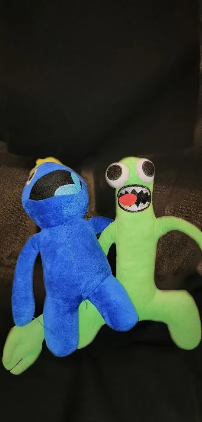 A playful blue and green plushie duo on a dark background.