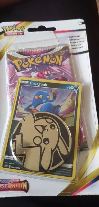 Pokemon card pack featuring Croagunk and colorful coin on display.