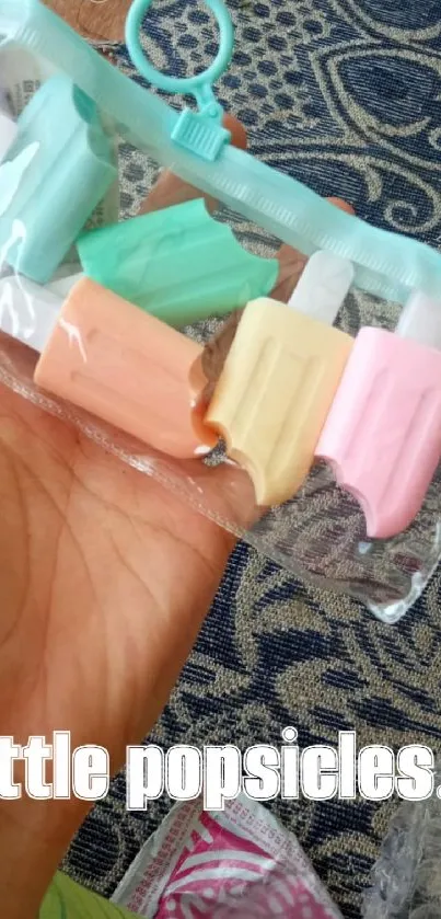 Hand holding colorful pastel popsicle erasers in a clear bag.