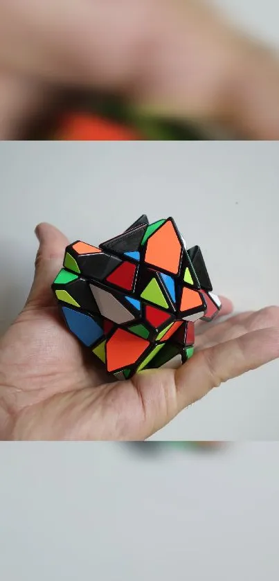 Colorful geometric puzzle cube held in hand.