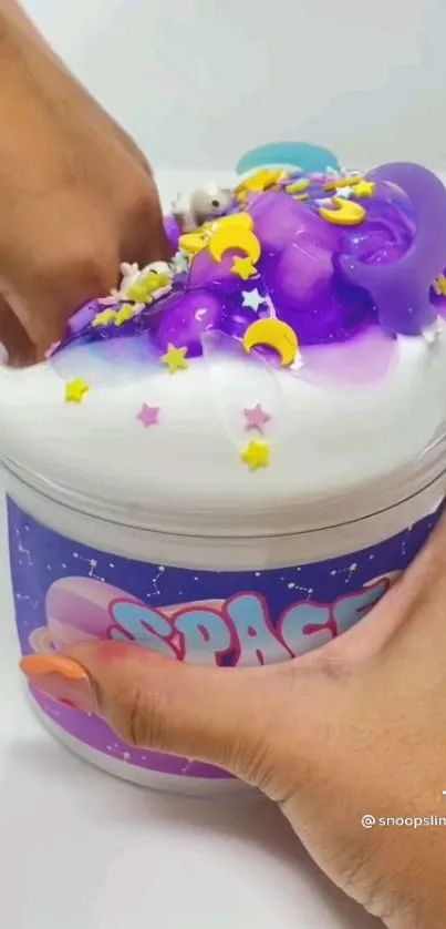 Hand playing with vibrant purple space-themed slime.