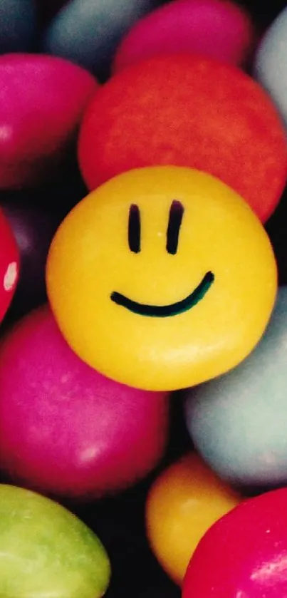 Yellow smiley candy among colorful sweets in wallpaper.