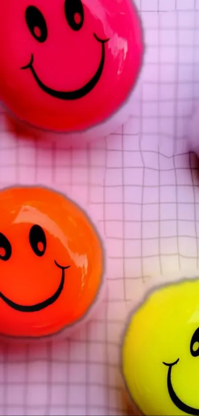 Colorful smiley faces on a grid wallpaper with vibrant neon hues.