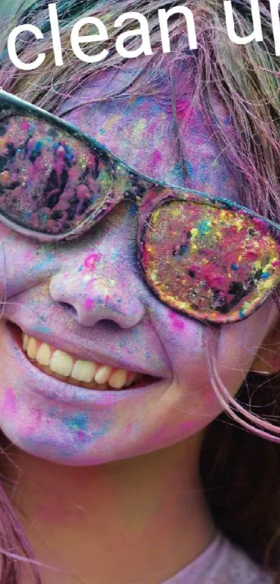 Smiling face with colorful Holi powders and sunglasses.