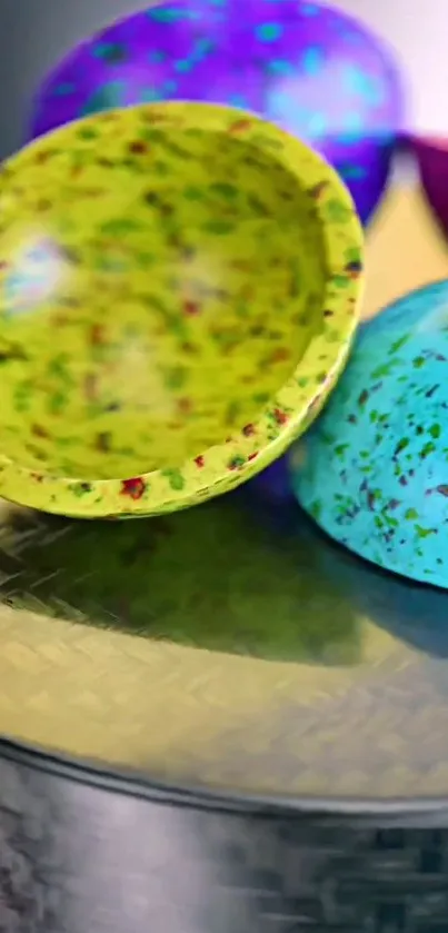 Abstract colorful speckled bowls on a reflective surface wallpaper.