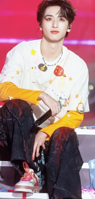Young performer on stage with colorful outfit and vibrant background.