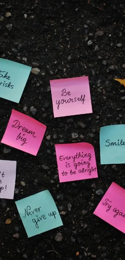 Colorful sticky notes and leaves on dark asphalt background.
