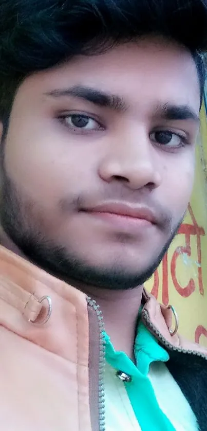 Young man in leather jacket with colorful street background.