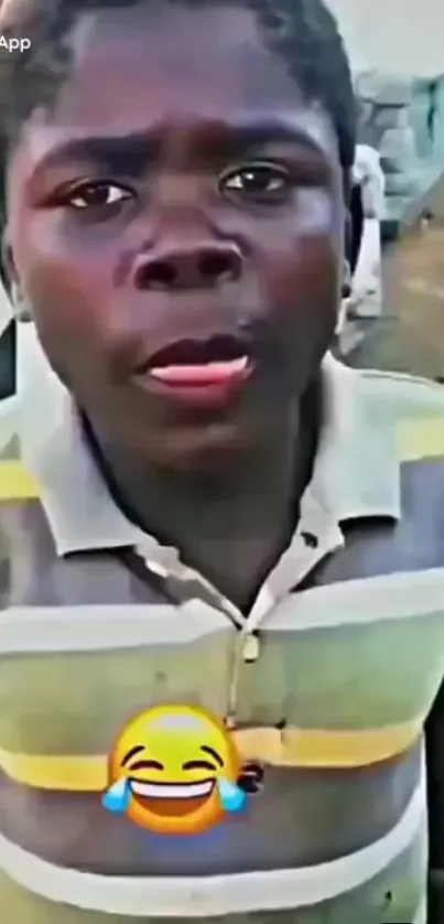 Boy wearing colorful striped shirt with laughing emoji.