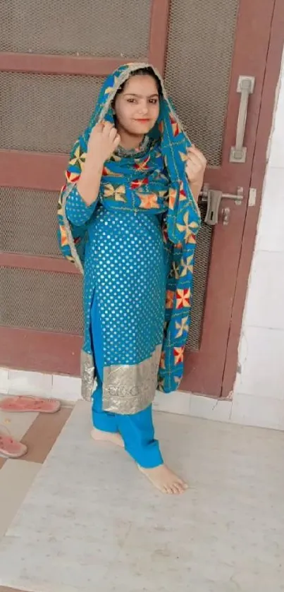 A woman in colorful traditional attire with blue and orange design.