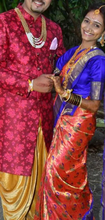 Indian couple in traditional, colorful wedding attire and jewelry.