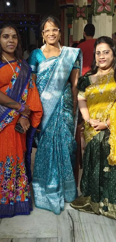 Women in traditional colorful sarees at an event.