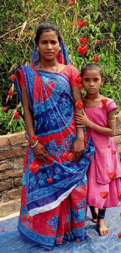 Woman and child in colorful attire with green background.