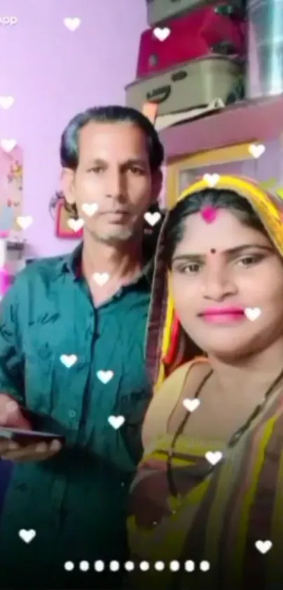 Couple in traditional attire with festive hearts decoration.