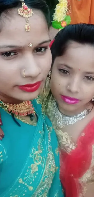 Two women in traditional attire capturing a festive moment.