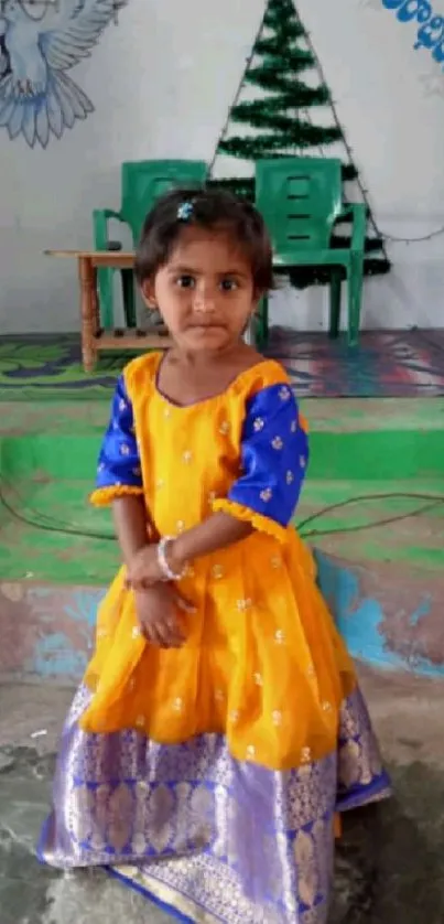 Child in colorful traditional dress with vibrant backdrop.