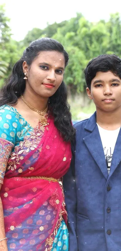 Family portrait in colorful traditional attire with lush green background.