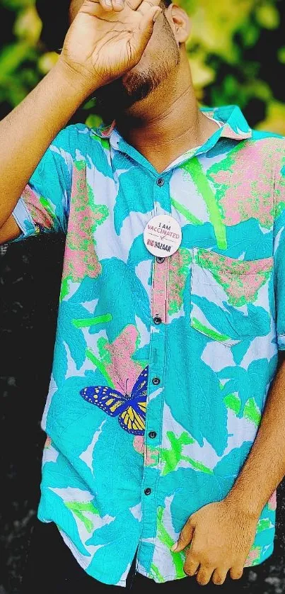 Person in colorful tropical shirt posing with peace sign.