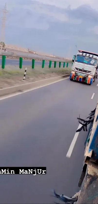 Colorful trucks driving on a highway with a cloudy sky background.