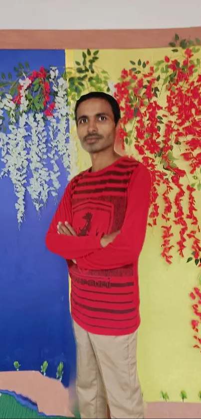 Person in red shirt with colorful floral wall art background.