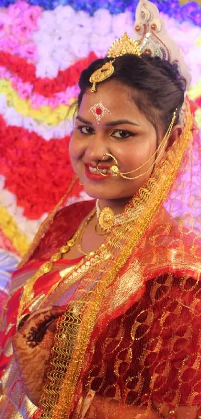 A woman in red traditional wedding attire with floral backdrop.