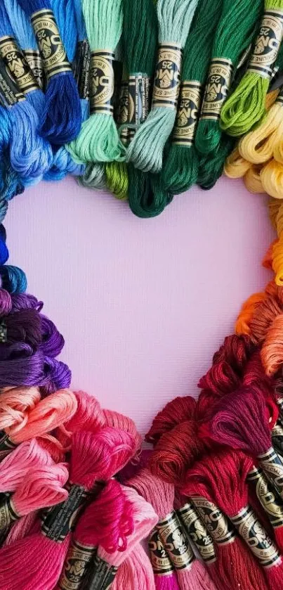 Colorful yarn forms a heart on a vibrant wallpaper.