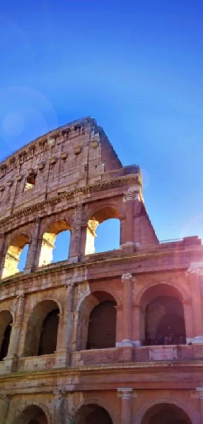 The Colosseum with sunlight against a clear blue sky, perfect mobile wallpaper.