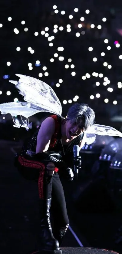 Person dressed as fairy performing at a concert with bright stage lights.