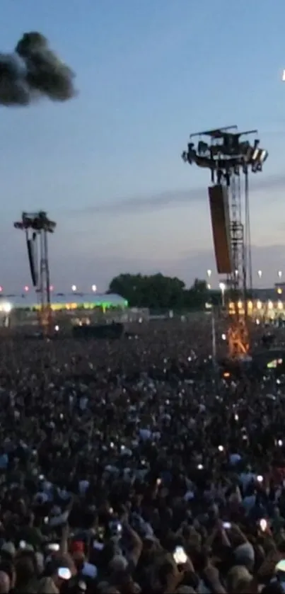 Crowd at a large outdoor concert during dusk.