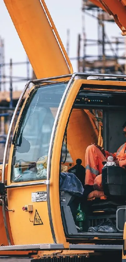 Close-up of a crane on a construction site with vibrant orange machinery.