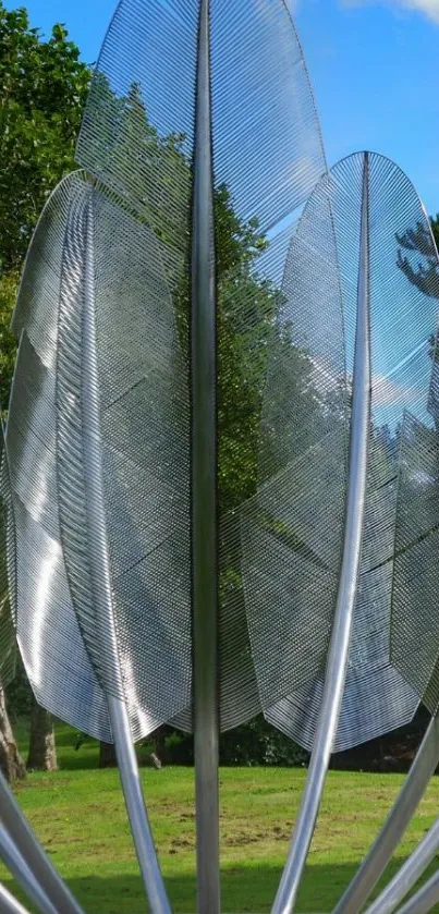 Modern metallic sculpture in a green park.